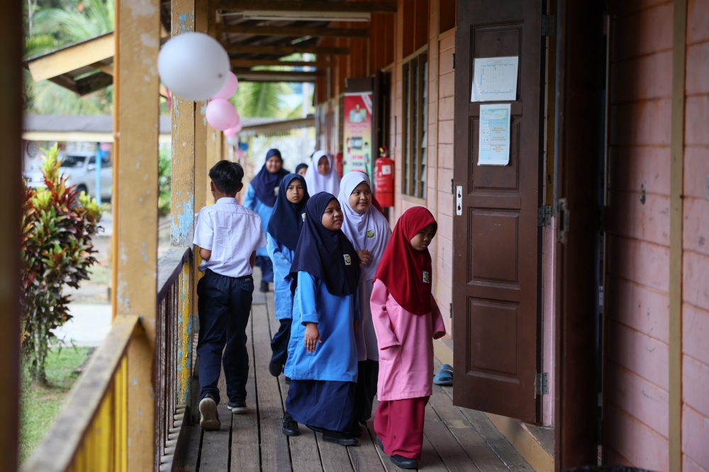Students are seen entering a classroom on the first day of school at Sekolah Kebangsaan Lintang, Jerangau in Dungun March 19, 2023. — Bernama pic
