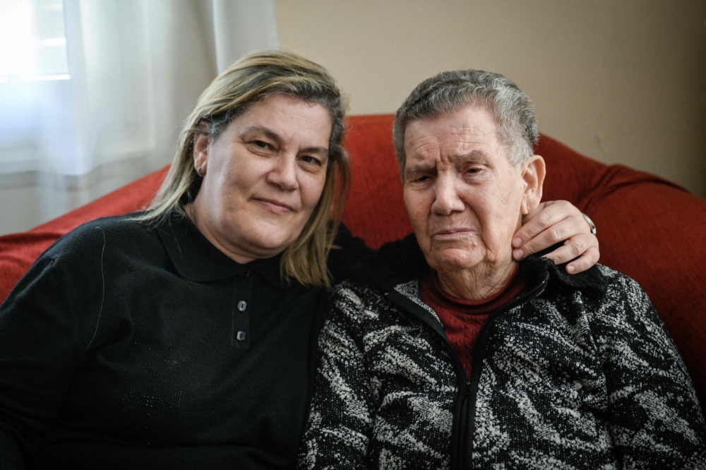 Holocaust survivor Naki Bega poses with her daughter Myriam at her home in Athens on March 14, 2023. — AFP pic