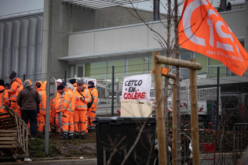 Unionists gather at an entrance to the Centre Technique Communautaire cleaning services centre, during strike action, near Le Havre, northwestern France March 20, 2023. — AFP pic