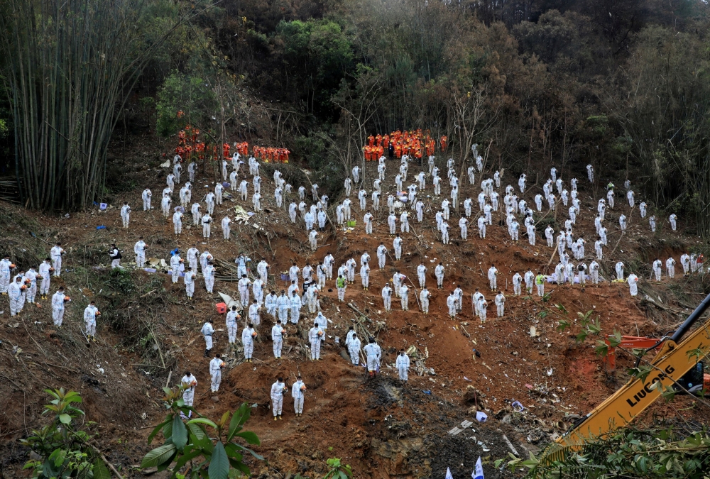 Rescue workers stand in a silent tribute at the site to mourn the victims of a China Eastern Airlines Boeing 737-800 plane, flight MU5735, that crashed in Wuzhou, Guangxi Zhuang Autonomous Region, China March 27, 2022. — Picture by cnsphoto via Reuters