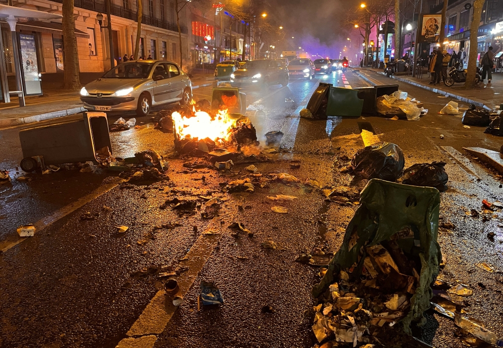 Drivers drive past burning garbage bins after a demonstration in Paris March 20, 2023. ¬— Reuters pic