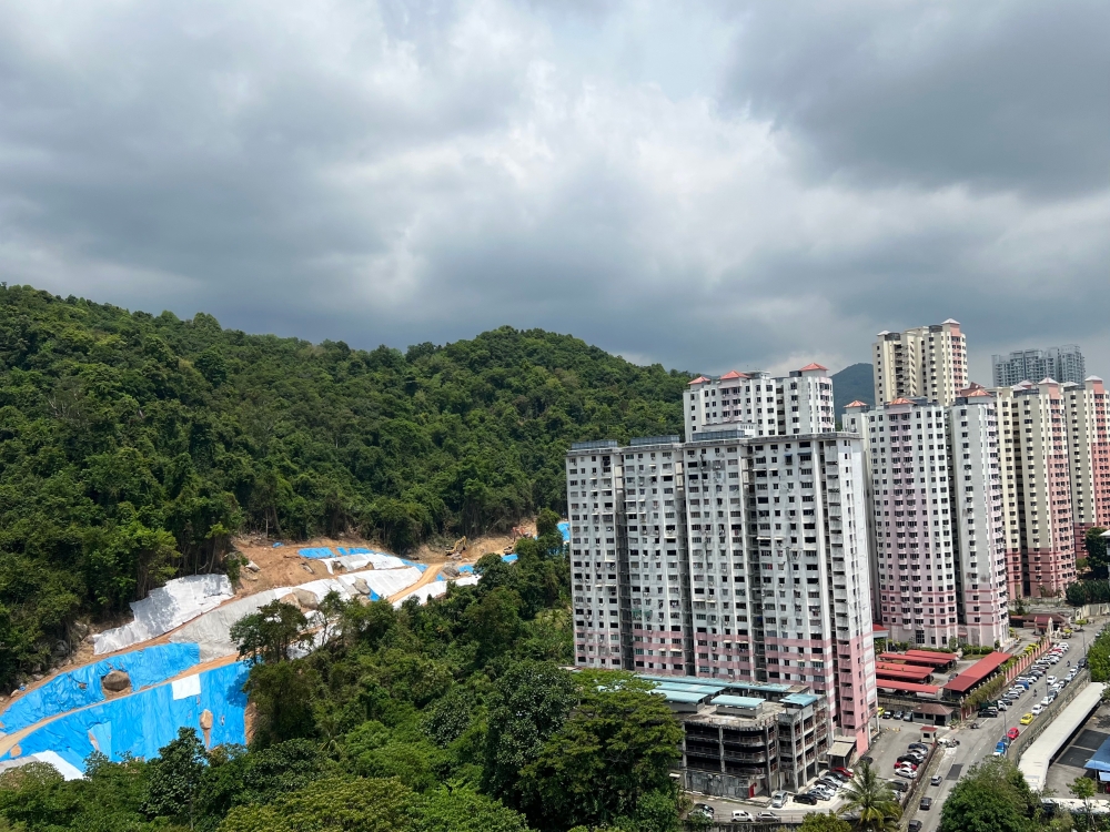 Residents of high rise buildings near the construction of a highway project in Penang on a precarious hill slope are living in fear of landslides due to large swatches of the hills being cleared for the project. — Picture by Opalyn Mok