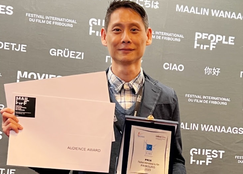A jubilant Ong with his two awards at the recently held 37th Fribourg International Film Festival. — Screen capture web via Facebook/More Entertainment