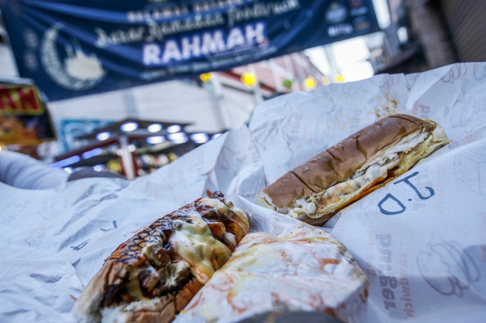 Lebai Pa King Kebab Station’s Menu Rahmah kebab chicken meat bun (left) compared to its beef mini Roti John (right) at the Ramadan Rahmah Foodtruck bazaar in Lorong Tuanku Abdul Rahman March 28, 2023. — Picture by Hari Anggara