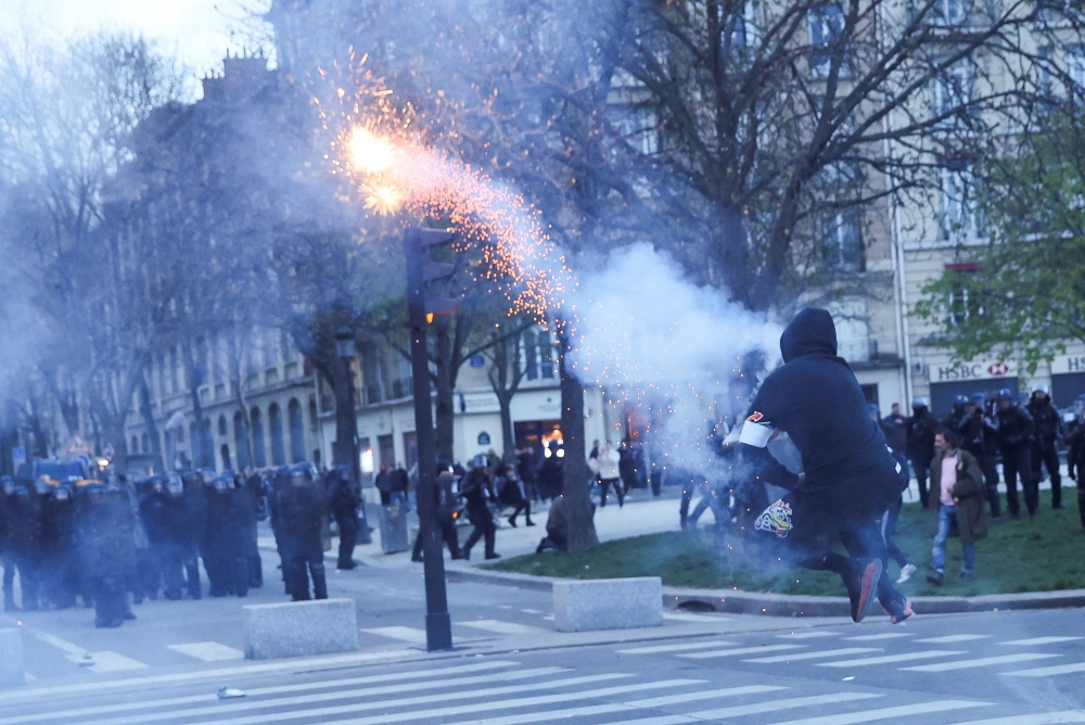 Black-clad groups set fire to garbage cans and threw projectiles at police in Paris, who charged at them and threw teargas in confrontations on the fringes of a march against President Emmanuel Macron and his deeply unpopular pension bill. — Reuters pic