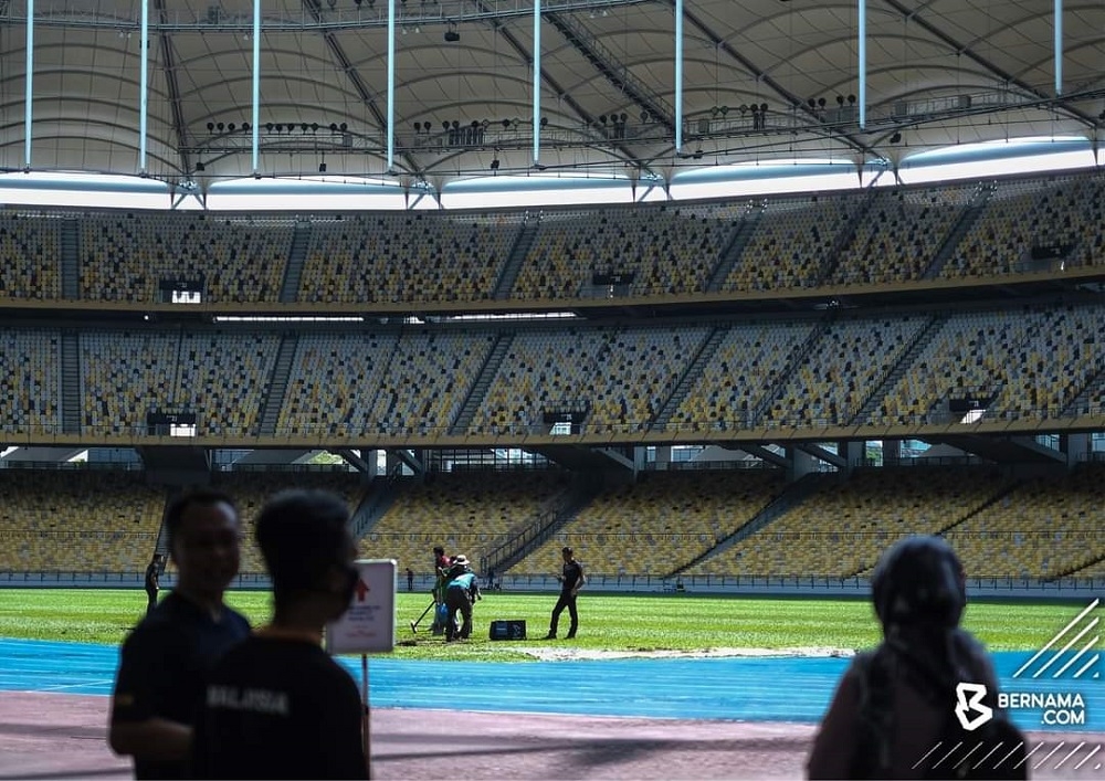 People are seen picking up grass turf at the Bukit Jalil National Stadium March 31, 2023. — Picture via Twitter/Bernama