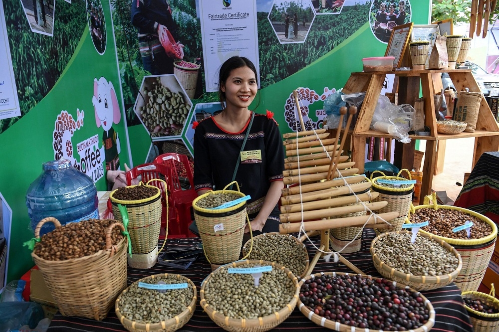 An ethnic Ede farmer sitting behind baskets of coffee beans at a coffee tasting fair in Buon Ma Thuot city in Daklak province. — AFP pic