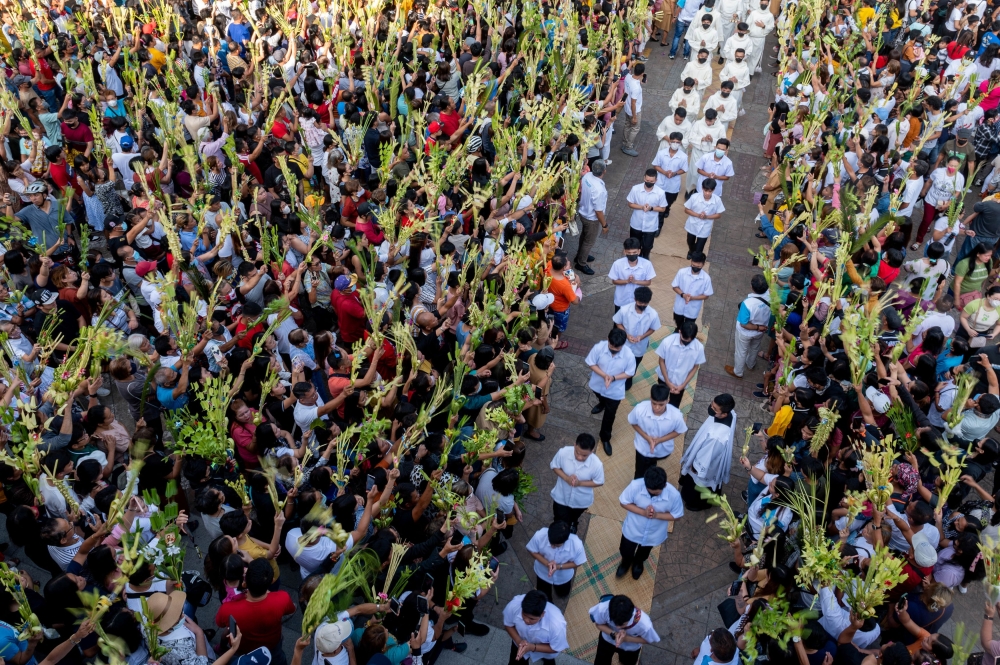 Filipino Catholics wave their palm fronds for blessing during a Palm Sunday mass at the Antipolo Cathedral in Antipolo City, Rizal province, Philippines, April 2, 2023. — Reuters pic