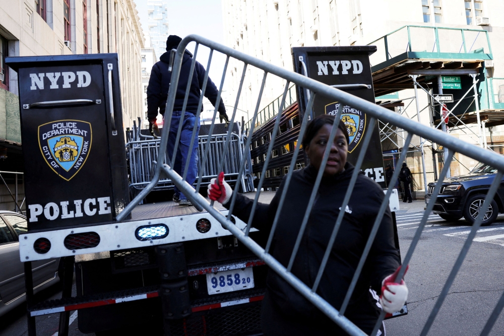 A person holds a barricade outside the Manhattan Criminal Court, after former US President Donald Trump's indictment by a Manhattan grand jury following a probe into hush money paid to porn star Stormy Daniels, in New York City April 2, 2023. — Reuters pic