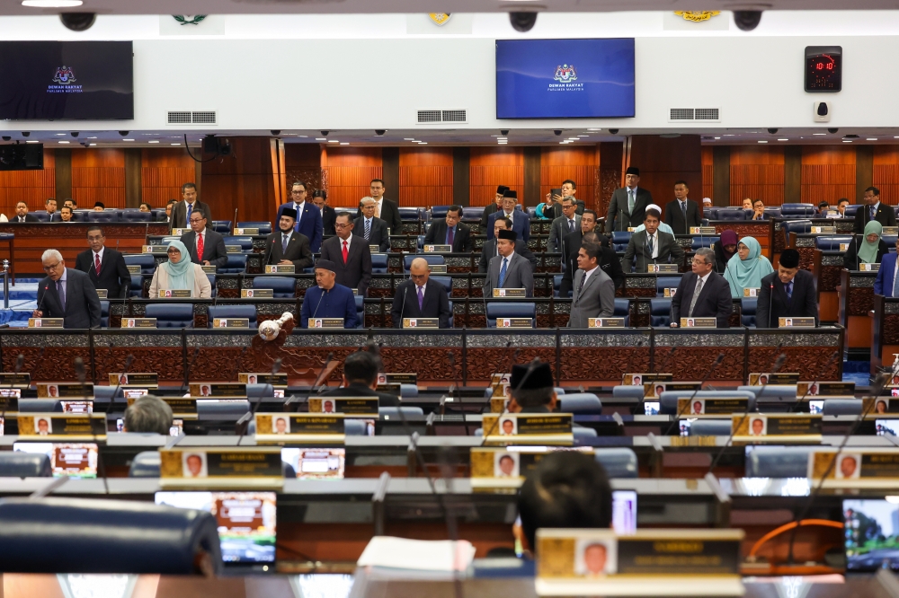 Opposition MPs, led by Opposition Leader Datuk Seri Hamzah Zainudin (left), stand in protest during a heated argument at the Parliament in Kuala Lumpur April 3, 2023. — Bernama pic