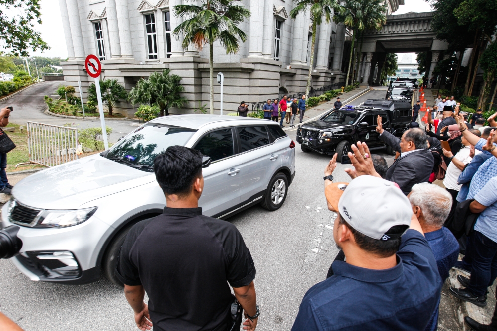 Supporters wave as a motorcade carrying former prime minister Datuk Seri Najib Razak leaves the compound after the SRC International case at the Palace of Justice February 28, 2023. — Picture by Sayuti Zainudin