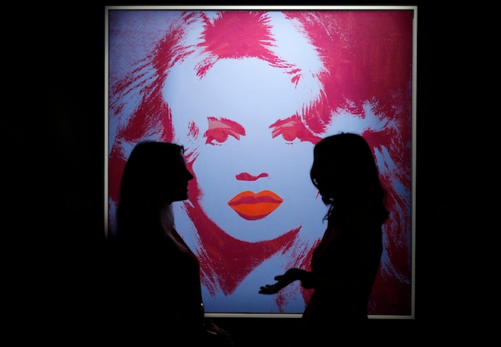 Staff members pose in a gallery near 'Brigitte Bardot' by Andy Warhol at Sotheby's auction house in London October 10, 2014. — Reuters pic
