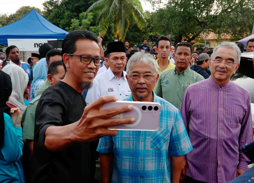 Yang di-Pertuan Agong Al-Sultan Abdullah Ri'ayatuddin Al-Mustafa Billah Shah agreeing to take a selfie with one of the visitors at the Peringgit Ramadan Bazaar, Melaka, April 5, 2023. — Bernama pic