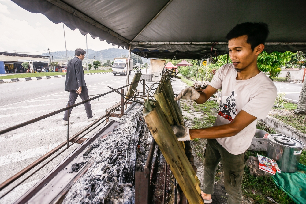 Khairul Anwar Mohd Yusop, 28, preparing lemang at his stall in Taman Jasa, Batu Caves, March 31, 2023. — Picture by Hari Anggara