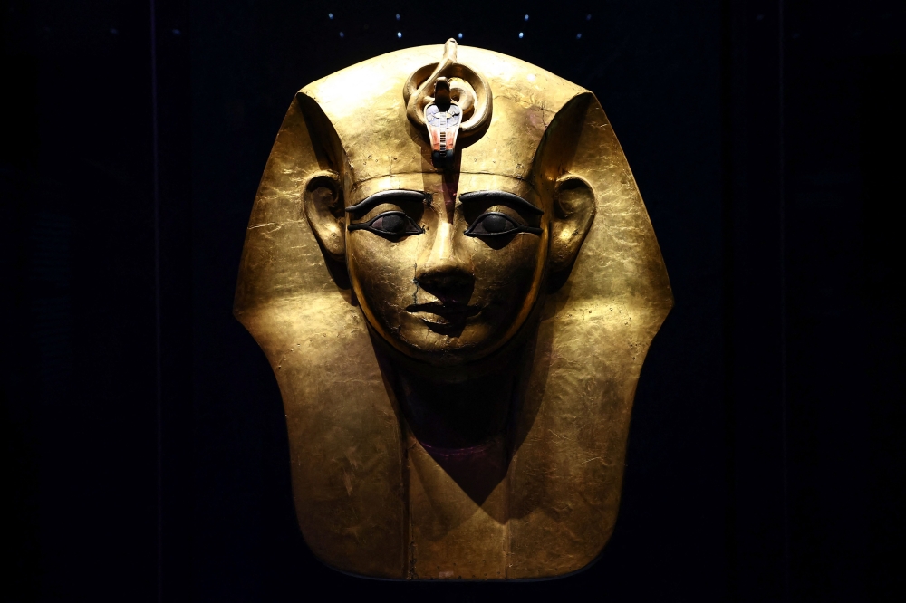A photograph taken on April 6, 2023 shows the Gilded Wooden Mask from the sarcophagus of Egyptian pharaoh Amenemope displayed on the opening day of the exhibition titled ‘Ramses and the Gold of the Pharaohs’ (Ramses et l’or des pharaons) at the Grande Halle de la Villette in Paris. — AFP pic