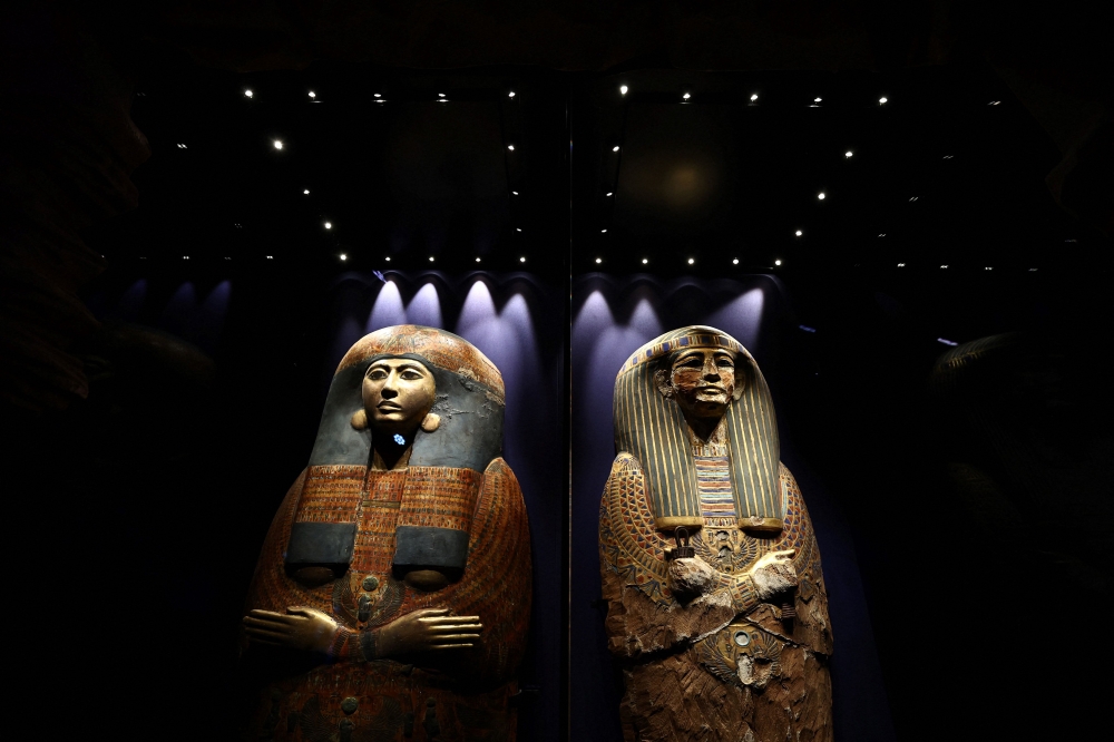 A photograph taken on April 6, 2023 shows the painted and gilded cedar outer coffin lid of Pinudjem II's wife, Princess Nesikhonsu, usurped from Istemkheb (left) and inner coffin lid or mummy board of Pinudjem I (right) on the opening day of the exhibition titled ‘Ramses and the Gold of the Pharaohs’ (Ramses et l’or des pharaons) at the Grande Halle de la Villette in Paris. — AFP pic