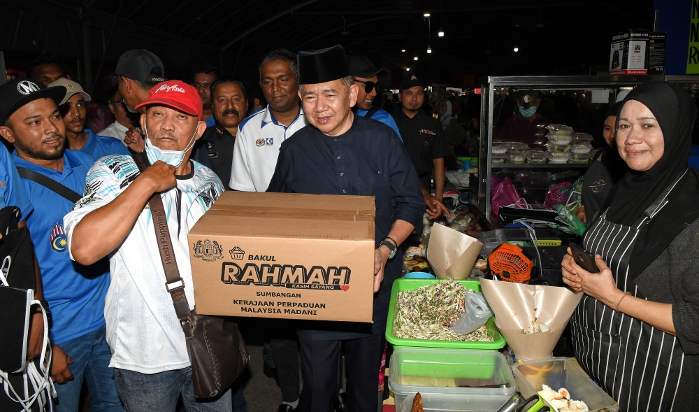 Domestic Trade and Cost of Living Minister Datuk Seri Salahuddin Ayub (2nd right) hands out a Bakul Rahmah box during the Bakul Rahmah programme in George Town April 7, 2023. — Bernama pic