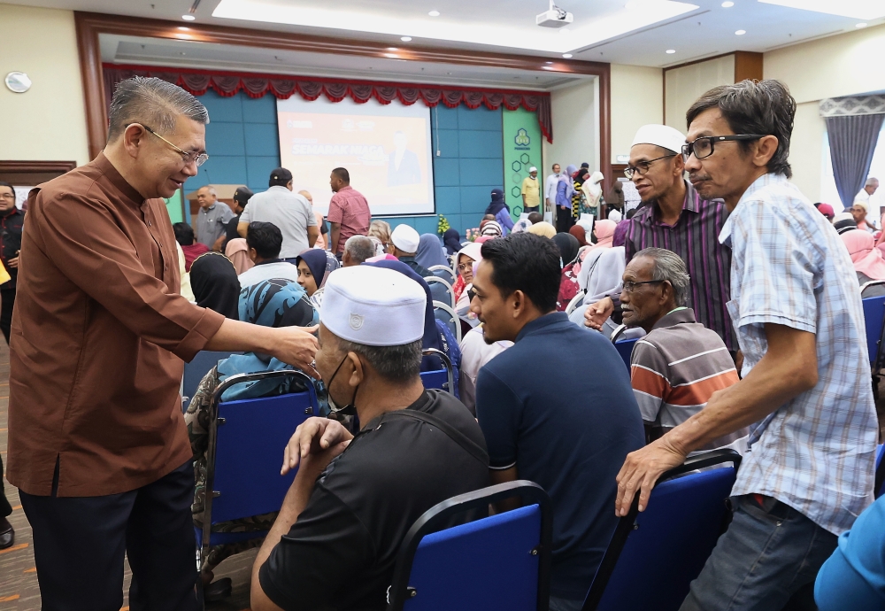 Domestic Trade and Cost of Living Minister Datuk Seri Salahuddin Ayub (left) greets attendees at the launch of the Companies Commission of Malaysia (SSM) Semarak Niaga programme in Alor Setar April 8, 2023. — Bernama pic