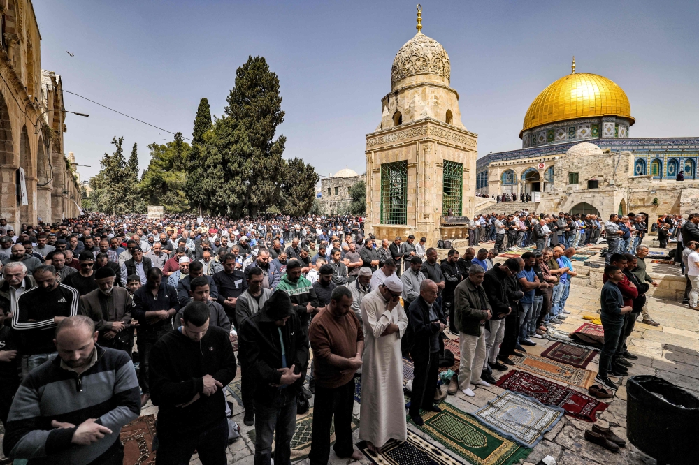 Muslim worshippers pray outside the Dome of the Rock shrine at al-Aqsa mosque compound in the Old City of Jerusalem on April 7, 2023 on the third Friday Noon prayer during the Muslim holy fasting month of Ramadan. — AFP pic