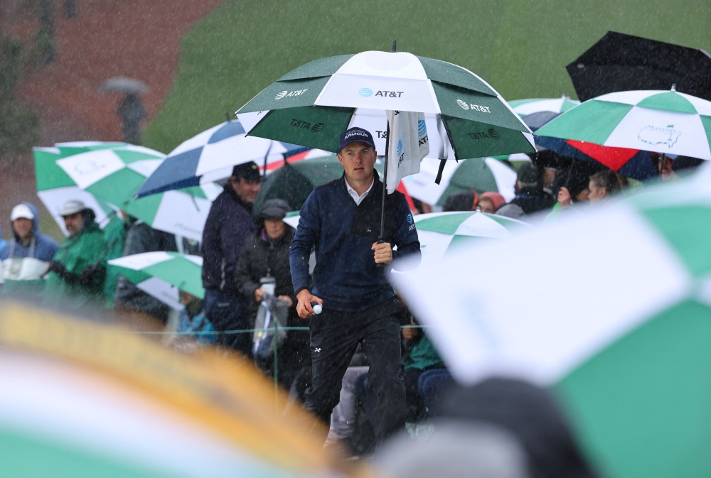 Jordan Spieth of the US walks off the course after play is suspended due to inclement weather conditions during the third round of The Masters at the Augusta National Golf Club at Augusta, Georgia April 8, 2023. — Reuters pic