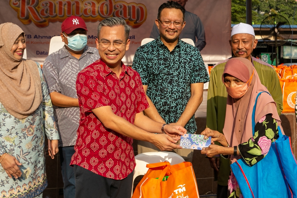 Communications and Digital Minister Fahmi Fadzil presenting a goodies bag to the PPR Kerinchi’s residents during the Sumbangan Cahaya Ramadan event at PPR Kerinchi,Pantai Dala, April 09, 2023. — Picture by Raymond Manuel