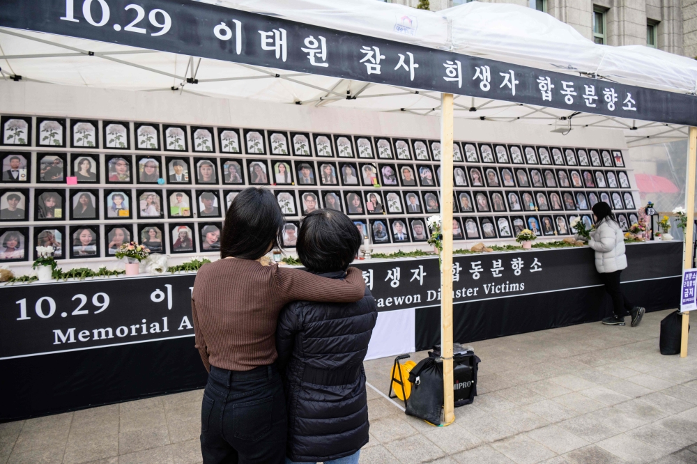 In this photo taken on March 8, 2023, Lee Ga-young (left), whose 24-year-old brother Lee Ji-han was killed in a Halloween crowd crush in the popular Itaewon district in October last year, hugs her mother Cho Mi-eun as they visit a public memorial in Seoul for those who died during the disaster. — AFP pic