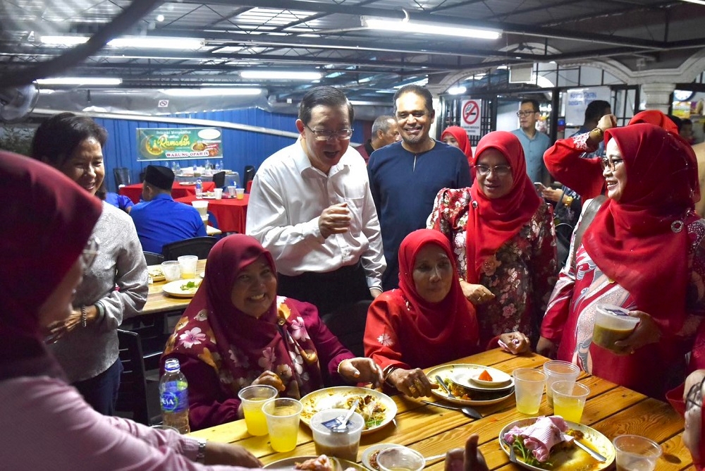 DAP chairman Lim Guan Eng and his wife Betty Chew speak to attendees during Umno’s Balik Pulau division porridge distribution and breaking fast event in Penang April 11, 2023. — Picture via Facebook/Lim Guan Eng