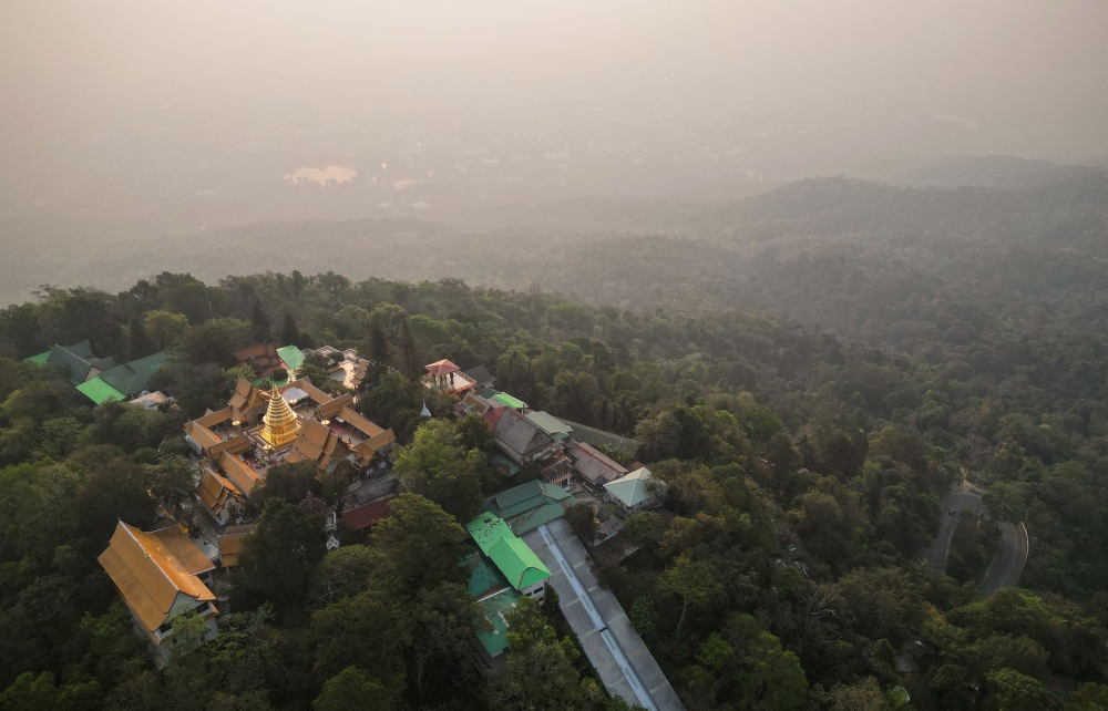 This aerial photo taken on April 11, 2023 shows Doi Suthep Buddhist temple in front of heavy pollution engulfing the city of Chiang Mai. — AFP pic