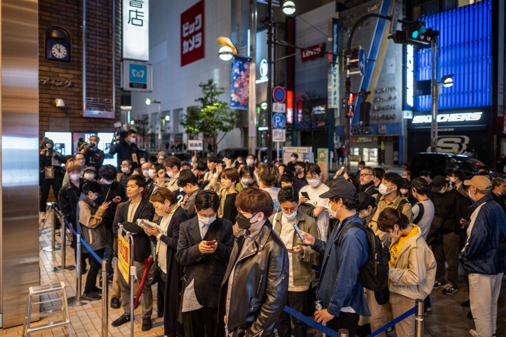 People line up to purchase the fresh copies of Japanese writer Haruki Murakami's new novella 