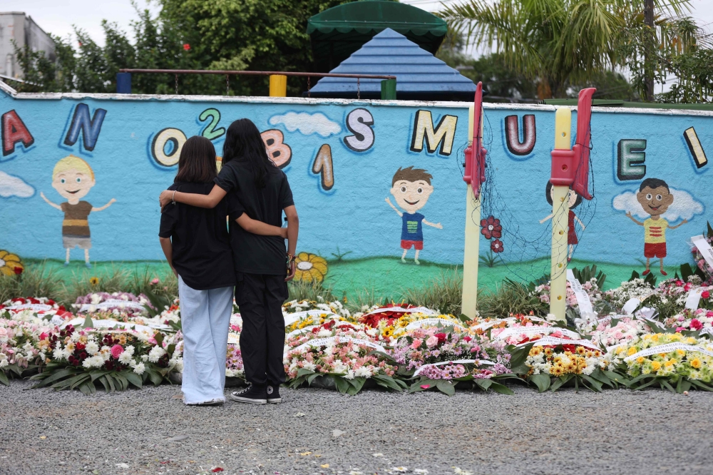 People take part in a vigil outside the Good Shepherd Center private preschool in Blumenau, Santa Catarina State, in southern BrazilApril 6, 2023. — AFP pic