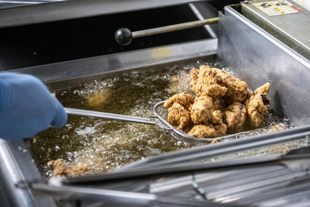 This picture taken on March 4, 2023 shows competitors cooking during the Karaage Grand Prix competition in Tokyo. — AFP pic