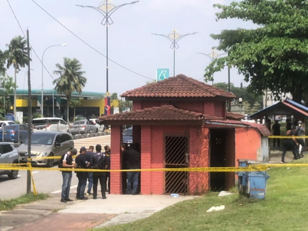 A decomposing body was found stuffed inside a suitcase abandoned at the Kulai Municipal Council’s bus kiosk in Kulai on Tuesday. — Picture courtesy of Kulai district police