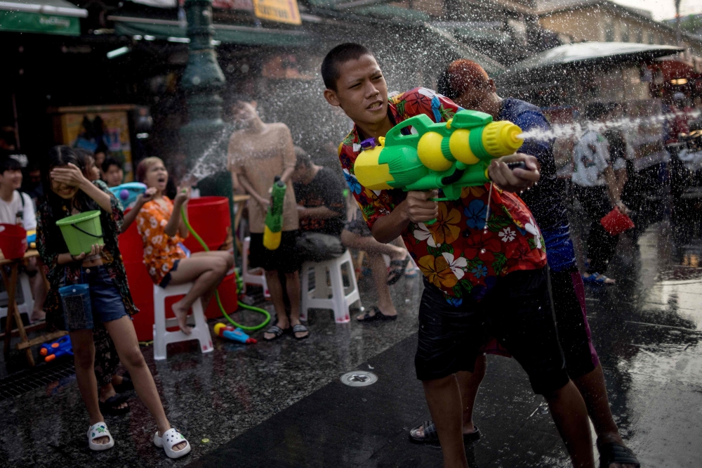 People take part in water fights during Songkran celebrations on Khao San Road in Bangkok. — AFP pic
