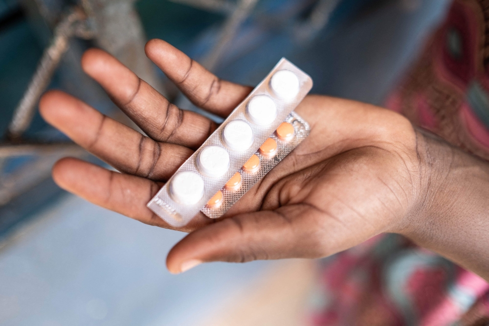 A patient shows medicines bought from Stephen Hyppolite Liosso Pivara Bembe, a former medical student who was never able to finish his studies, in the small street pharmacy he owns in Bangui. — AFP pic