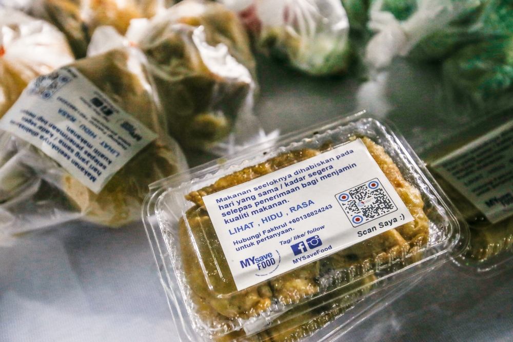 'Kuih' make up the most of unsold goods from bazaars. Gema would put stickers on repackaged food with instructions so recipients will not get food poisoning April 12, 2023. — Picture by Hari Anggara