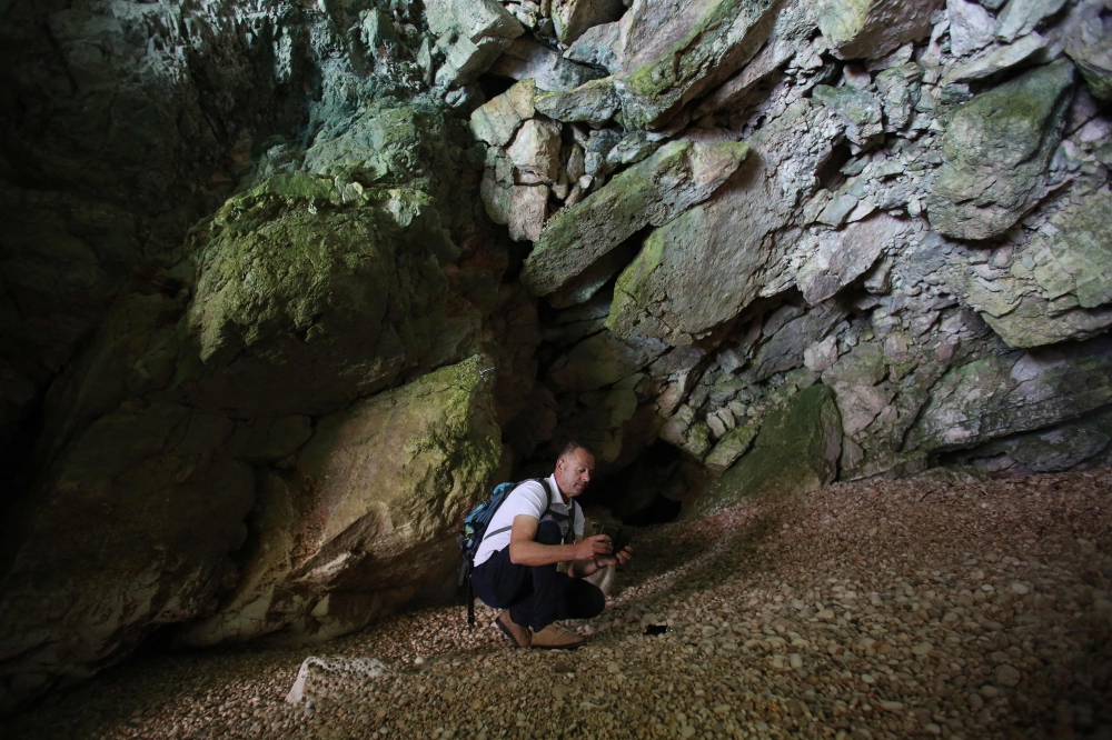 Nexhip Hysolokaj, a biodiversity expert, installs a camera trap inside a cave, a habitat used by Mediterranean monk seals (Monachus monachus), at the Karaburun peninsula. — AFP pic