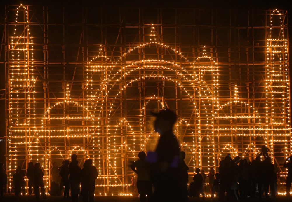 With Hari Raya Aidilfitri around the corner, Kampung Ribu villagers at Enggor, Kuala Kangsar are putting up pelita panjut (traditional bamboo oil lamps). This year, they decided to put a pelita panjut with the Masjid Wilayah Kuala Lumpur design. Preparation began a month before Ramadan with the gathering of bamboo. The design is 9.5 metres in height and 15 metres wide. A total of 1,600 oil lamps were used to light up the pelita panjut. — Picture by Farhan Najib