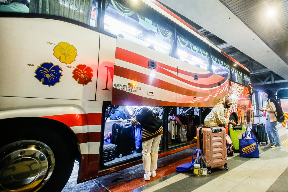 A general picture of passengers loading their luggage onto a bus at Terminal Bersepadu Selatan April 19, 2023. — Picture by Hari Anggara