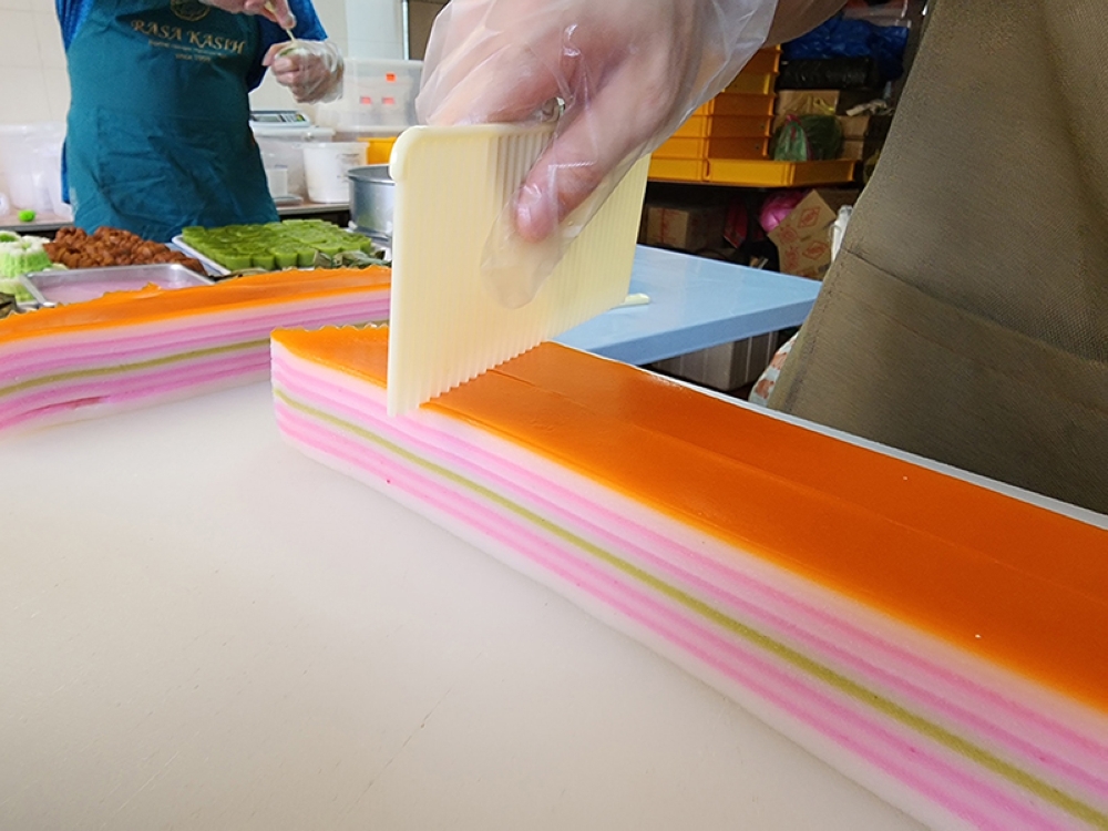 The 'kuih lapis' being cut into serving sizes.