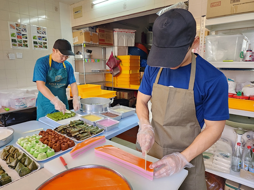Baylon Tham and Cheng Wei Da (right) getting the various 'kuih' ready for the stall.