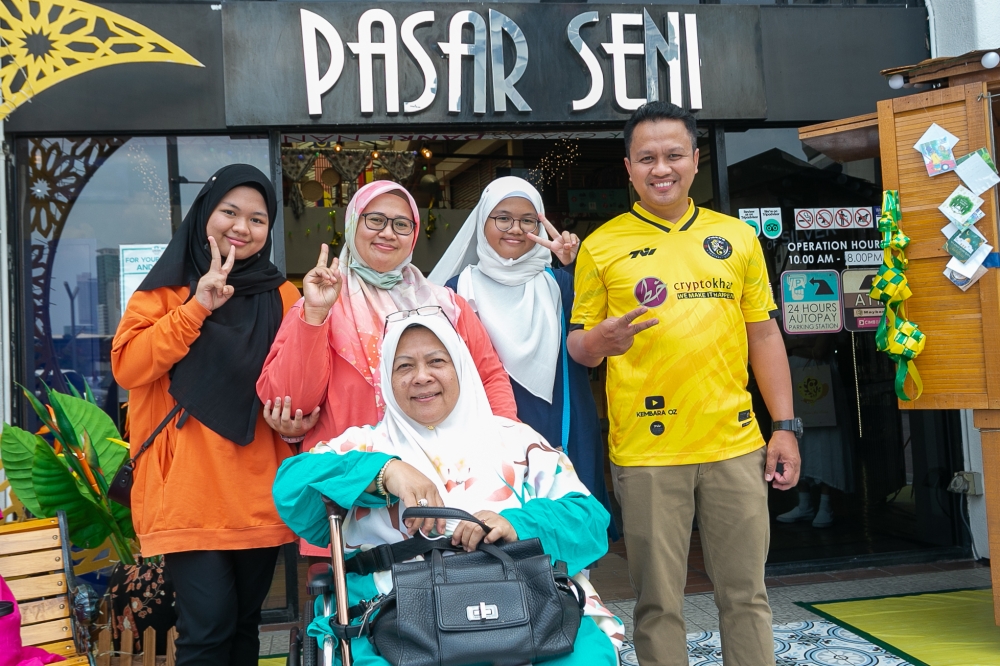 Abdul Rafik Othman, 43, and his family pose for a picture at Pasar Seni during the extended holiday for Hari Raya Aidilfitri April 24, 2023. — Picture by Raymond Manuel