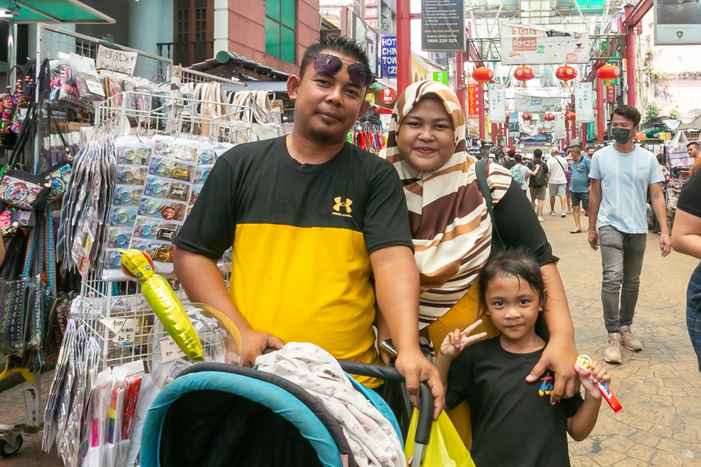 Lilis Arianie Zainadine, 29, is seen with her family at Petaling Street during the extended holiday for Hari Raya Aidilfitri April 24, 2023. — Picture by Raymond Manuel