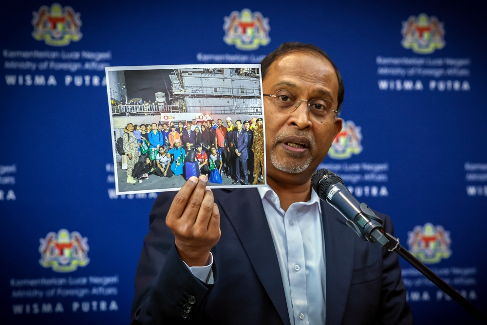 Foreign Minister Datuk Seri Dr Zambry Abdul Kadir showing photos of Malaysians brought out of Sudan at a press conference at Wisma Putra, April 27, 2023. — Bernama pic