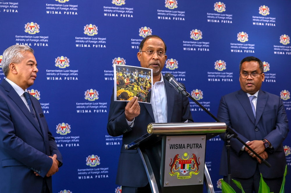 Foreign Minister Datuk Seri Zambry Abdul Kadir shows a photo of Malaysians brought out of Sudan at a press conference at Wisma Putra, Putrajaya April 27, 2023. — Bernama pic