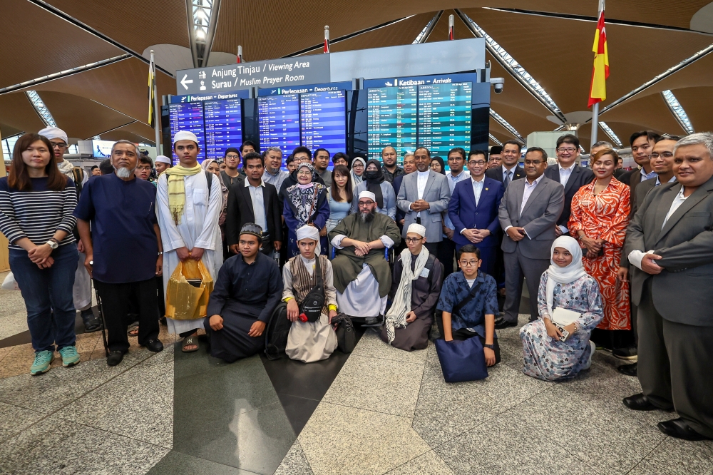 Foreign Minister Datuk Seri Zambry Abdul Kadir poses for a picture with 30 Malaysians who returned from Sudan at the Kuala Lumpur International Airport in Sepang April 28, 2023. — Bernama pic