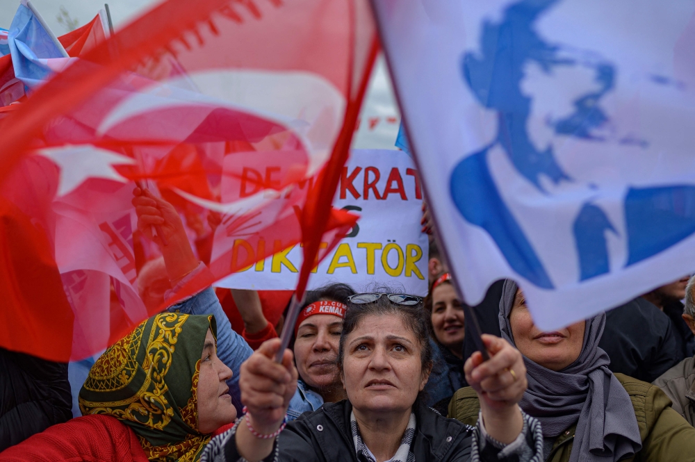 A Supporter waves flags during a rally in support of Republican People’s Party (CHP) Chairman and Presidential candidate Kemal Kilicdaroglu in Kocaeli, on April 28, 2023. - A sea of umbrellas and hoods at his feet, Kemal Kilicdaroglu, the Turkish opposition candidate who will challenge Recep Tayyip Erdogan at the polls on 14 May, smilingly promises ‘the return of spring’. ― AFP pic