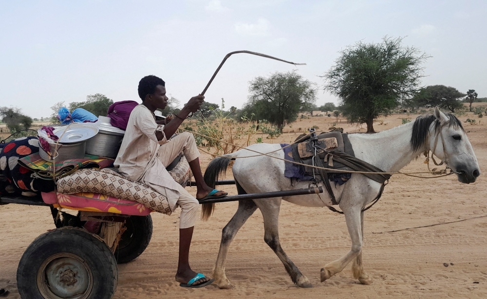 File photo of a Sudanese man, who fled the violence in his country, drives his cart loaded with his belongings as he crosses the border between Sudan and Chad in Koufroun, Chad April 27, 2023. ― Reuters pic