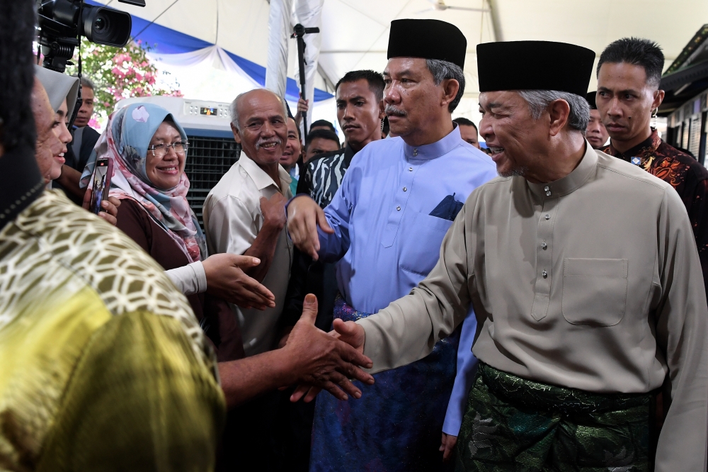 BN president Datuk Seri Ahmad Zahid Hamidi (right) and deputy chairman Datuk Seri Mohamad Hasan (2nd right) greet guests at the latter’s Aidilfitri Open House in Kampung Tanjong, Rantau, Seremban April 30, 2023. — Bernama pic