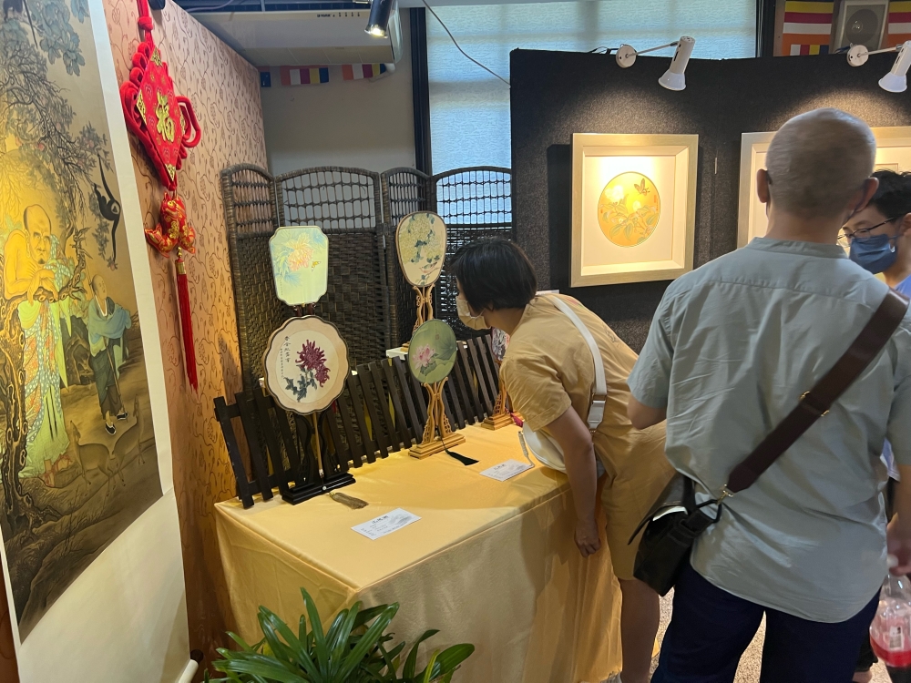 Visitors observe art at an exhibition of three different Buddhism traditions at the Malaysian Buddhist Association in George Town. — Picture by Opalyn Mok