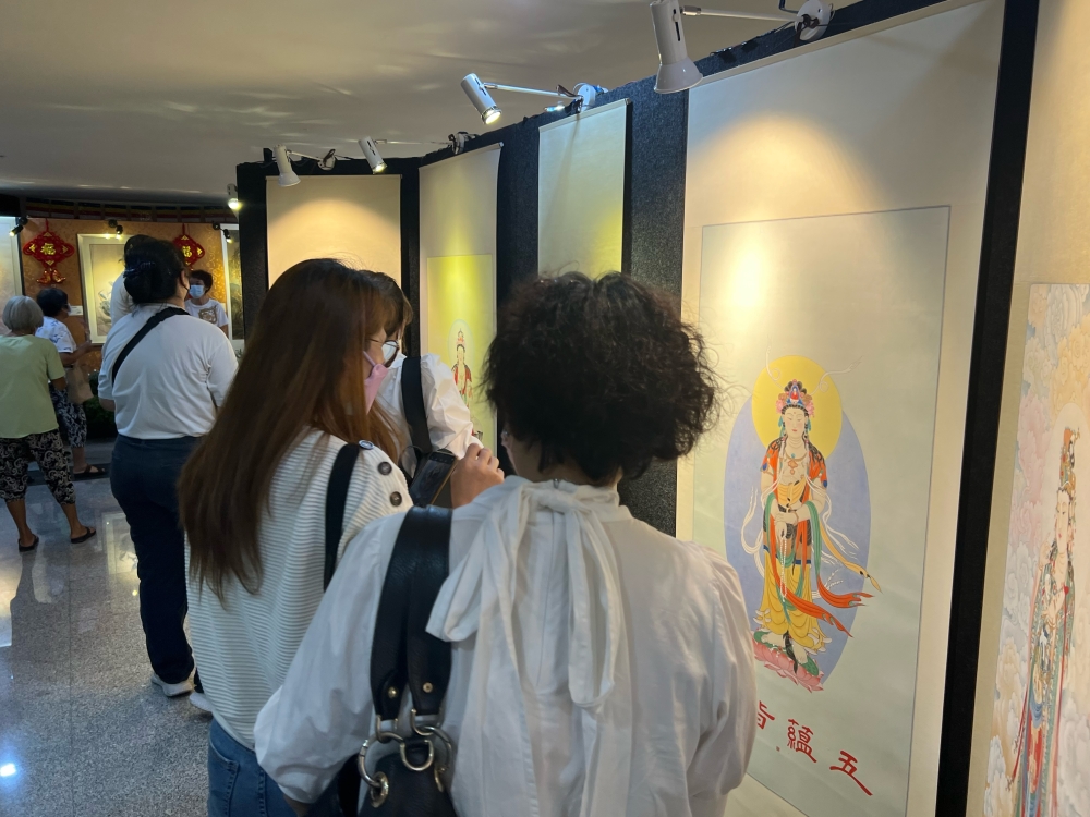Visitors look at paintings displayed at the Malaysian Buddhist Association in George Town. — Picture by Opalyn Mok